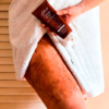 Mujer aplicándose el exfoliante corporal reductor cacao sense