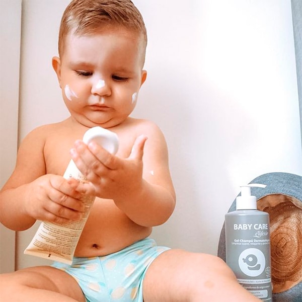Niño con crema facial hidratante para bebés